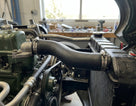 Black radiator hose fitted between engine block and radiator in a classic car engine bay