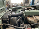 Top radiator hose fitted in situ on a green classic car's engine