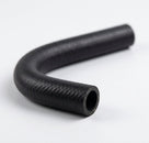 Black textured heater hose curved into a tight loop, studio shot