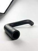 Textured black rubber hose with a right-angle bend, studio close-up