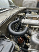 Black heater inlet hose fitted near the carburettors in a classic car engine bay