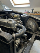 Top radiator hose fitted in the engine bay of a stripped Triumph TR7