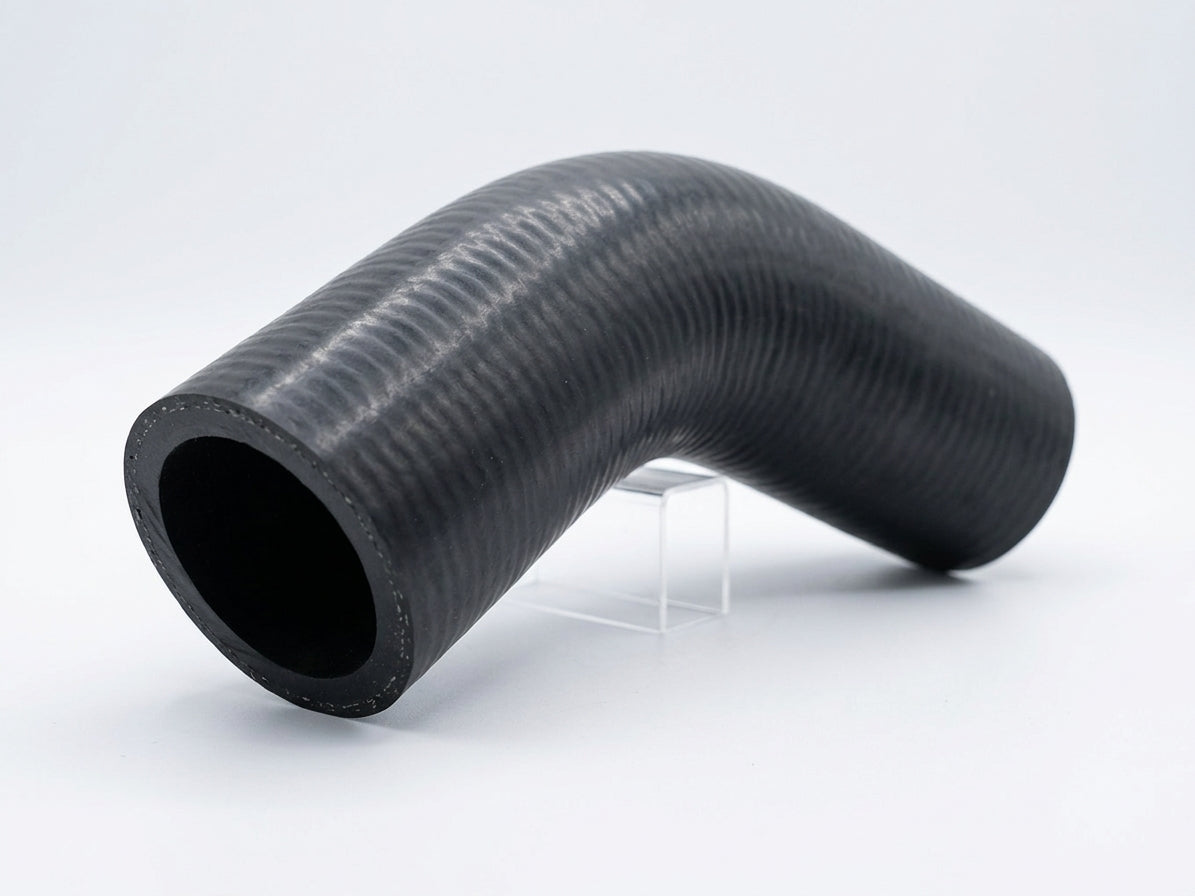 Textured black rubber hose with a curved bend, studio shot on white