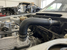 Hose fitted between the carburettor and cylinder head of a classic engine
