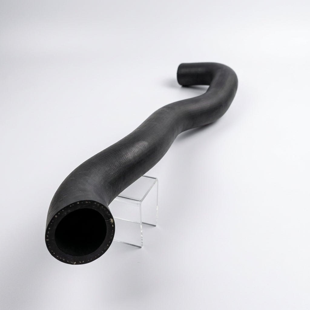 Black top radiator hose with pronounced S-bend, studio shot on stand