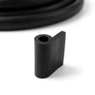 Short cut length of black solid neoprene hollow piping with hooked flange, coiled length behind