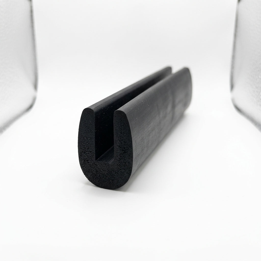 Black neoprene U-channel edge trim standing upright, studio softbox photo of rounded block
