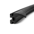 Black T-section rubber seal shown at an angle, slotted side channels visible