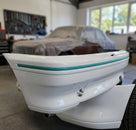 Green trim strip fitted to a detached white bumper section in a workshop