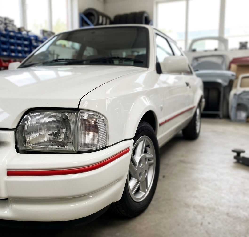 White Escort Mk4 with red bumper trim fitted along the lower body edge