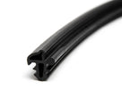 Black rubber trim seal with barbed leg profile, coiled length on white background