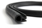 Black rubber door seal with hollow bulb and barb, coiled length on white background