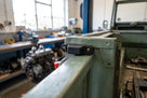 Rubber buffer bolted to a green tailgate frame, engine parts in background