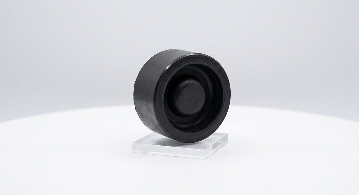 Round black rubber bonnet buffer on a stand, side view, white background