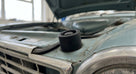 Black bonnet buffer fitted to a pale green classic Cortina's bonnet edge
