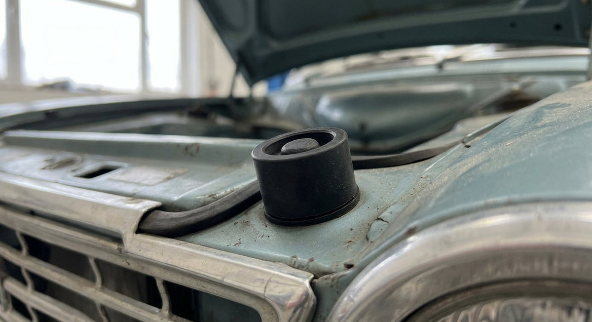 Black bonnet buffer fitted to a pale green classic Cortina's bonnet edge