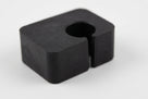 Black rubber seat adjusting block fitted on a car floor pan beside the seat rail