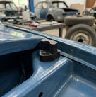 Black rubber bonnet buffer fitted to the inner wing edge of a blue Triumph Stag
