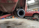 Exhaust mounting ring fitted to the tailpipe of a red Triumph, underside view
