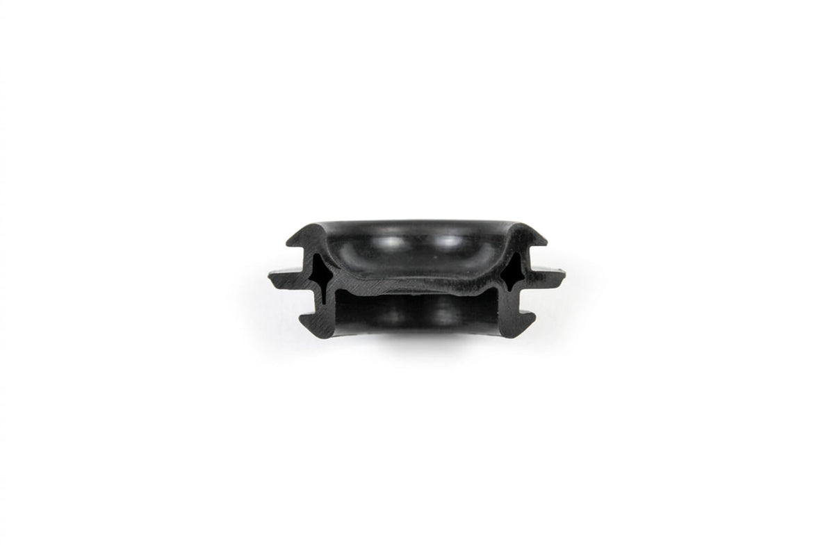 Black rubber sill plug with slotted sides, top-down studio shot