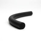 Black sponge rubber cord curved into a hook shape on a white studio background