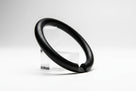 Black nitrile O-ring propped on a clear stand, studio shot on white