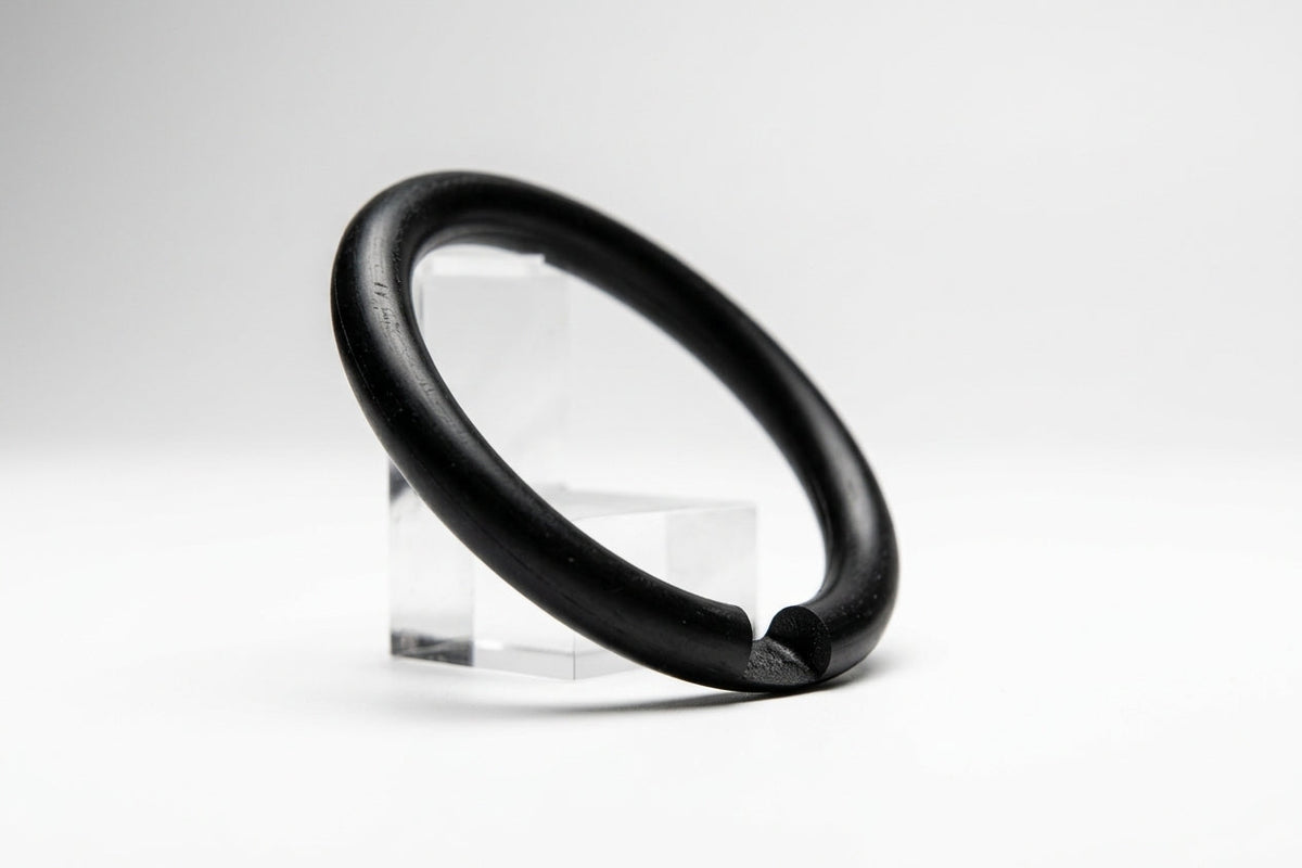 Black nitrile O-ring propped on a clear stand, studio shot on white