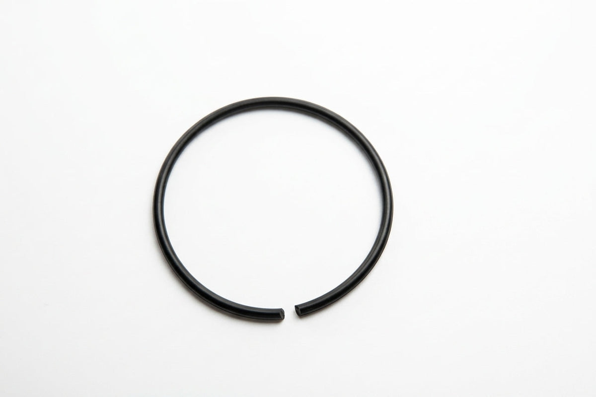 Large black nitrile O-ring laid flat, overhead shot on white background
