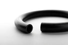 Macro shot of a thick black O-ring with cut ends visible, on white background