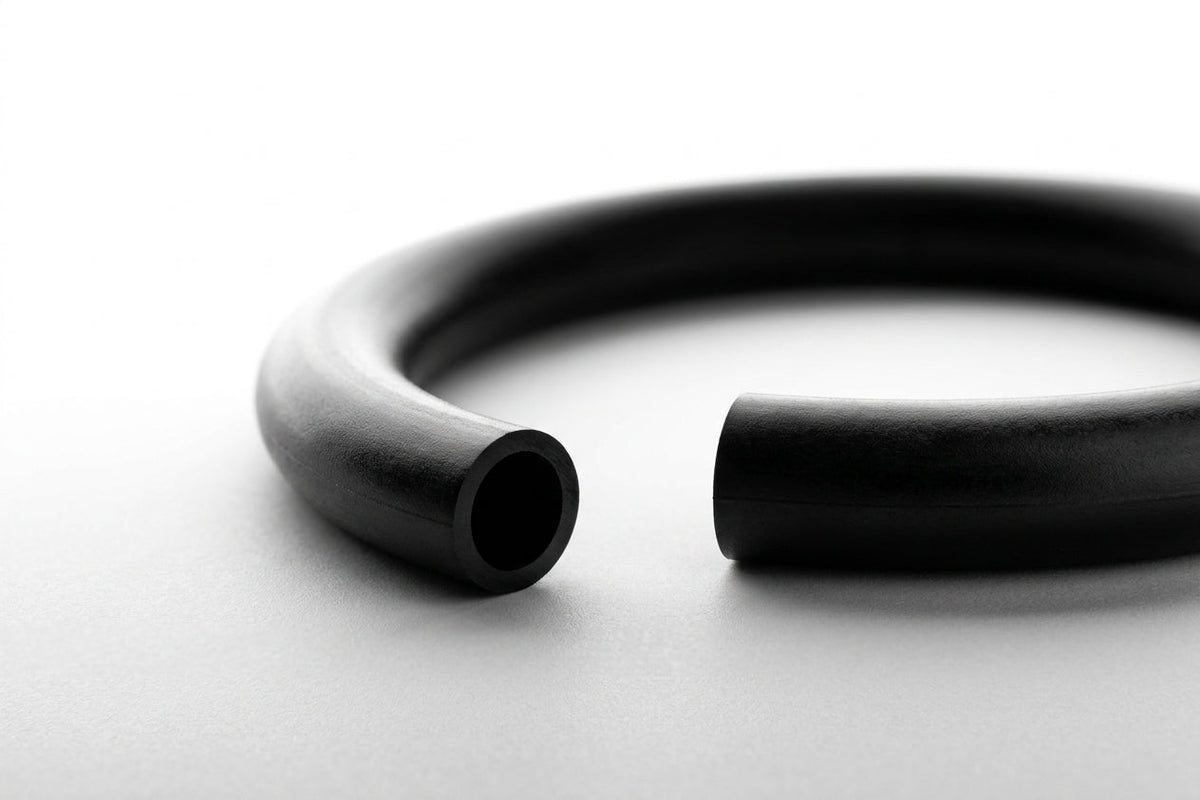 Macro shot of a thick black O-ring with cut ends visible, on white background