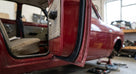 Black flocked door seal fitted around a red classic car's open door aperture