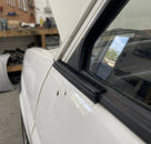 Flocked black outer waist strip fitted along a white car's window edge