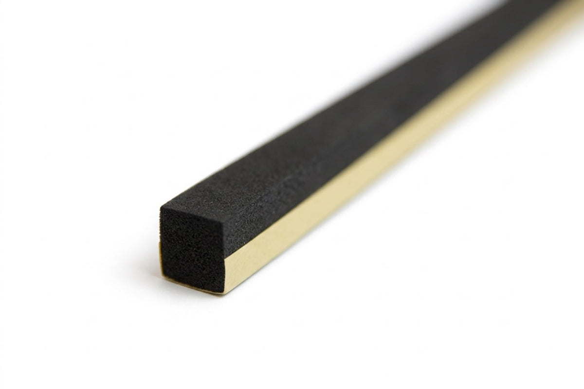 Small square black foam strip shown at an angle with gold adhesive backing