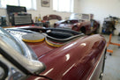 Self-adhesive foam strip fitted along a maroon classic car's bonnet edge