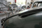 Self-adhesive foam strip fitted along a green classic car's bonnet edge