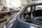 Self-adhesive foam strip fitted along a dark blue classic car's window edge