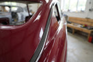 Black self-adhesive foam strip fitted along a maroon classic car's window trim
