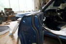 Self-adhesive foam strip fitted along a dark blue classic car's door edge, roll shown