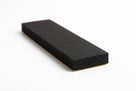 Black foam strip block shown at an angle with gold adhesive backing paper