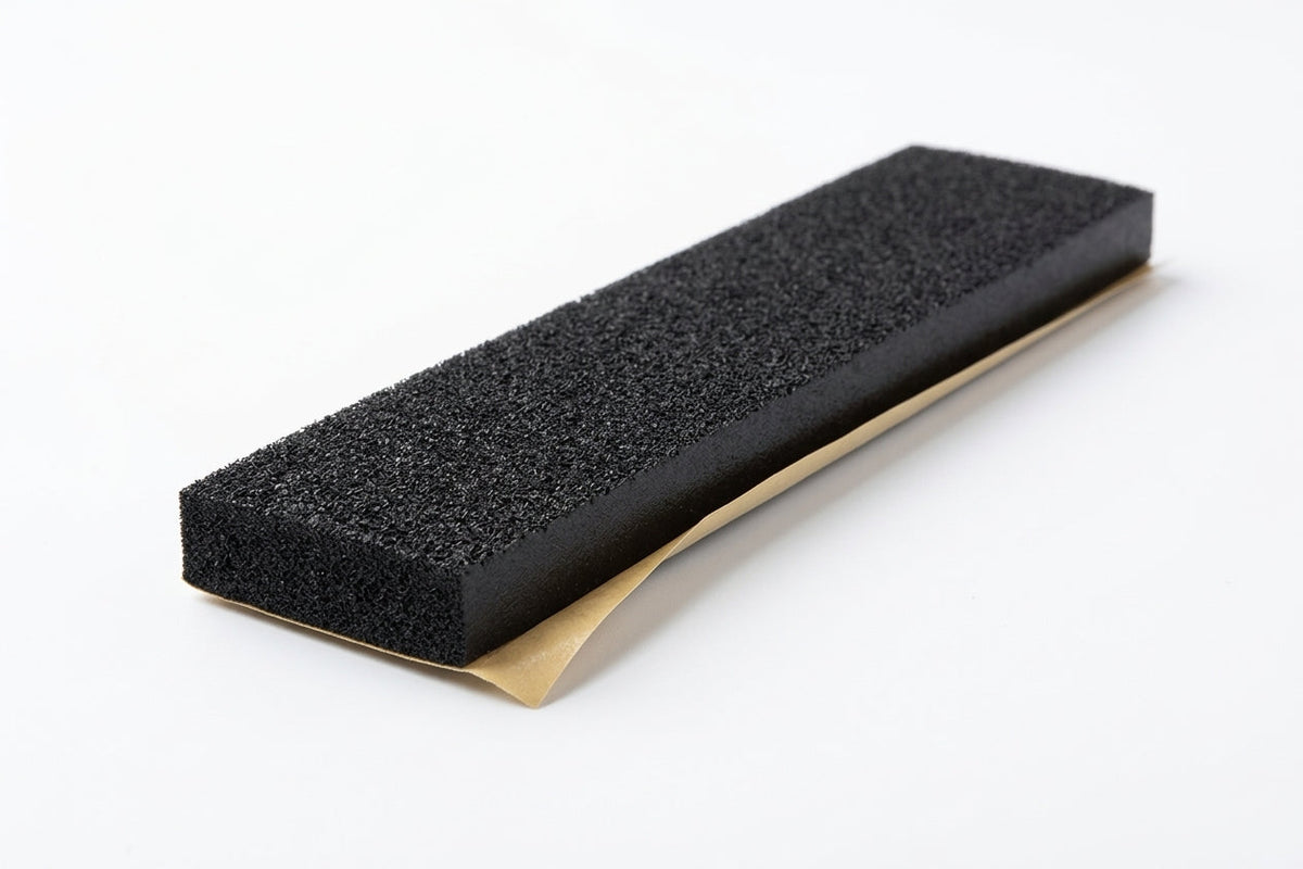 Black foam strip block shown at an angle, gold adhesive backing along one edge