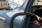 Self-adhesive foam strip fitted along a blue classic car's window pillar