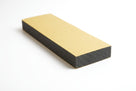 Wide black foam strip block shown with gold adhesive backing facing upward