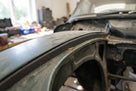 Self-adhesive foam strip fitted along a green classic car's bonnet edge, backing exposed