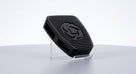 Black ribbed rubber pedal pad with circular logo motif, studio shot on clear stand