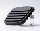 Black ribbed rubber brake pedal pad propped upright on a white background