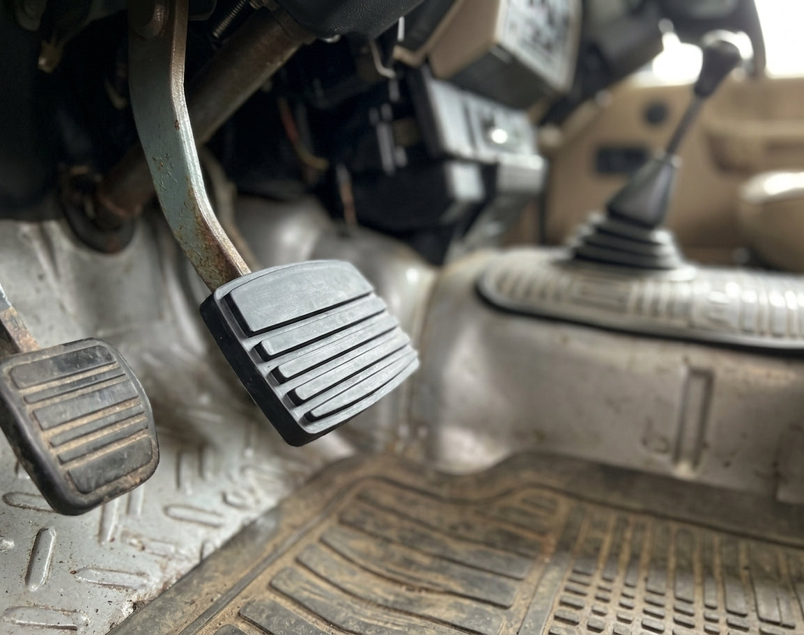 Ribbed brake pedal fitted in a dusty Land Rover footwell, close-up view