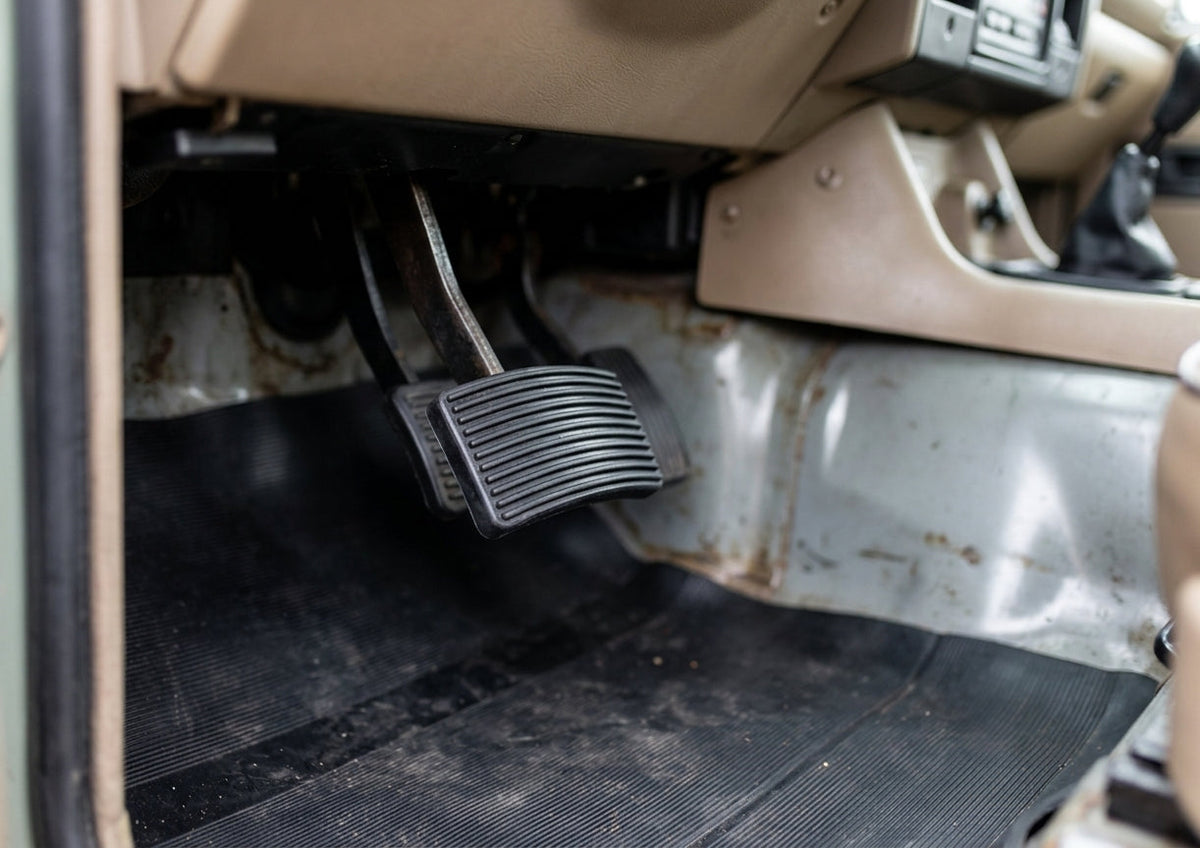 Ribbed pedal pad fitted in a Land Rover footwell, dashboard and gear lever visible