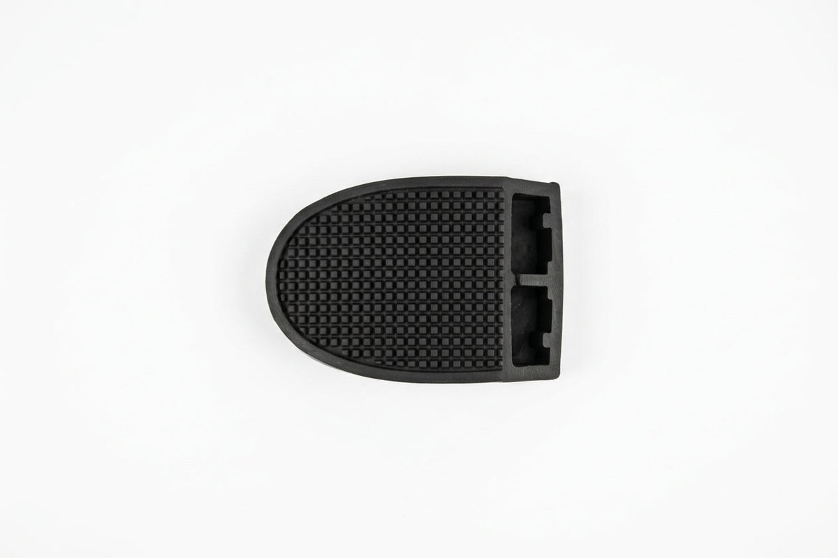 Rounded rubber pedal pad with fine cross-hatch texture, top-down studio shot