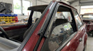 Black A-pillar seal fitted to a maroon Escort's windscreen pillar in a workshop