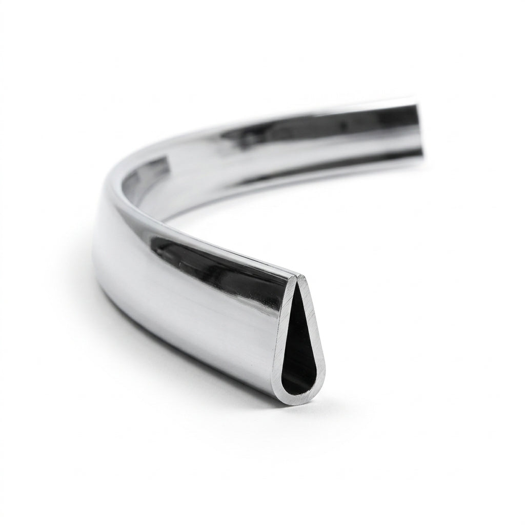 Curved length of chrome plastic trim with narrow teardrop channel, studio shot
